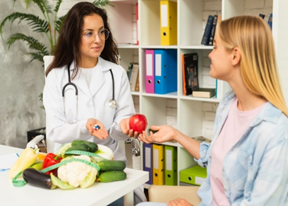 a doctor giving an apple to a patient